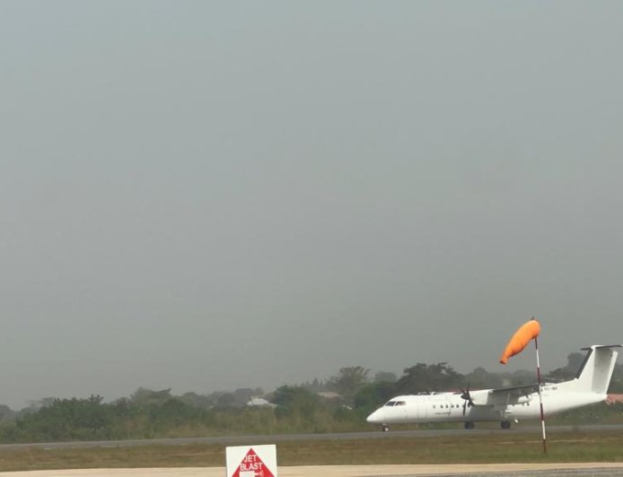 Club members observing runway operations at Sunyani Airport, witnessing aircraft takeoffs and landings.